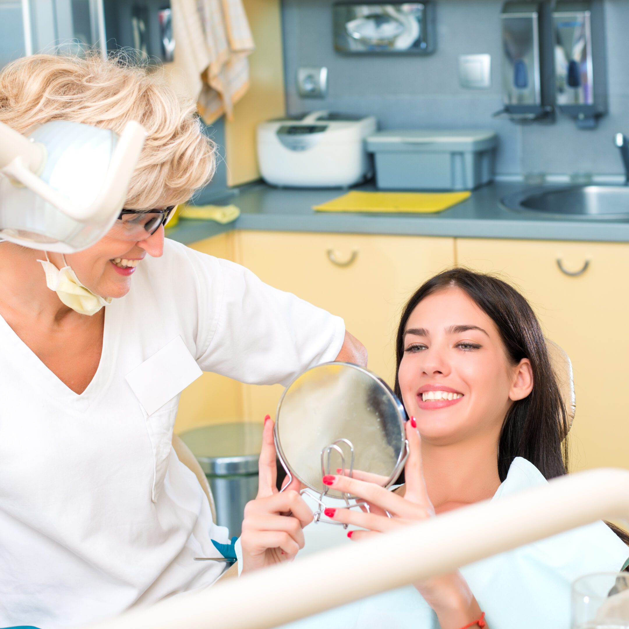 Woman holding mirror at dental office