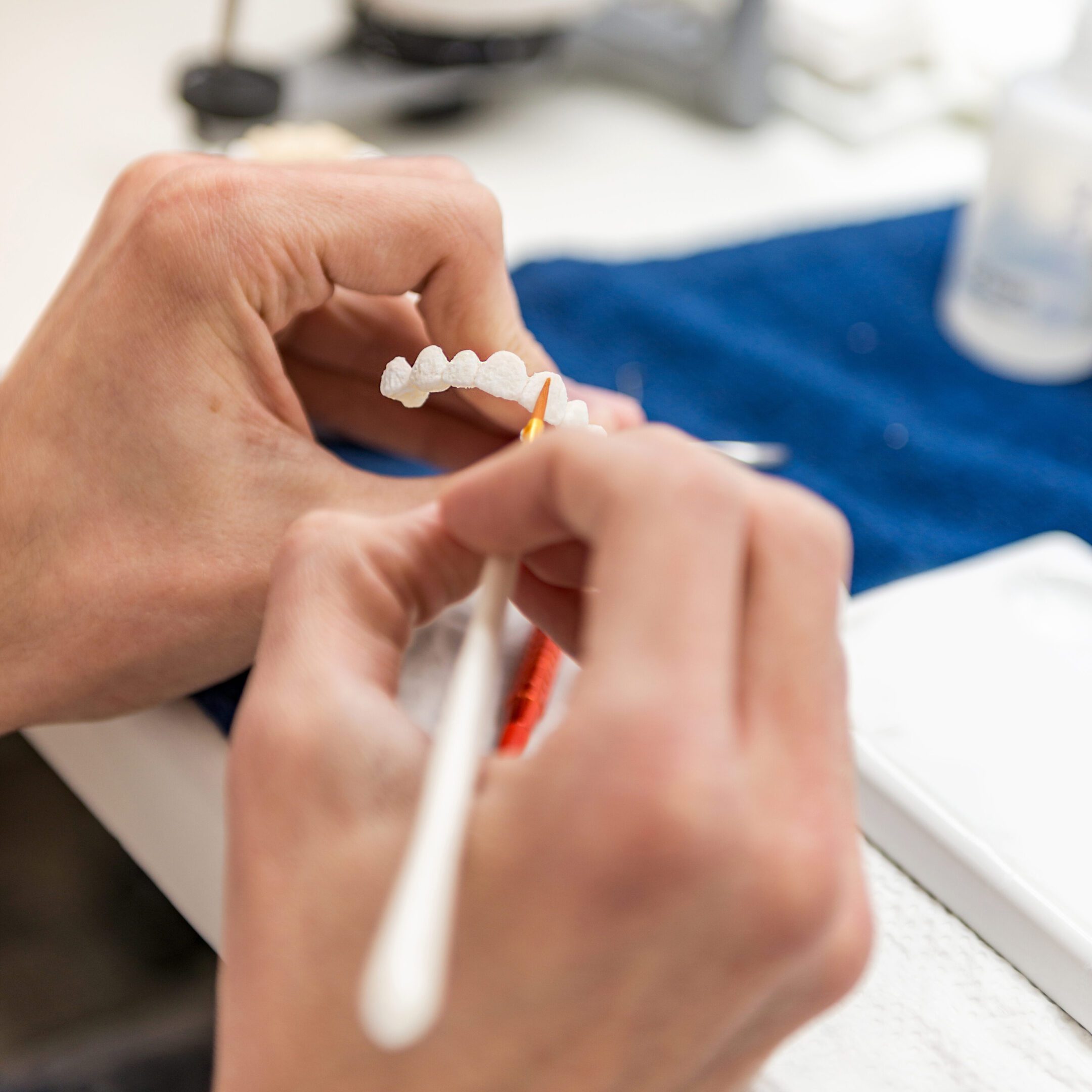 Hands painting dental prosthetic model